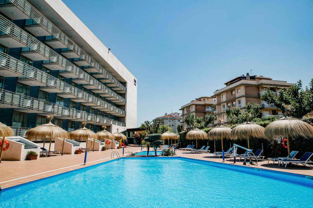 Outdoor pool with sun loungers at Sol Port Cambrils Hotel