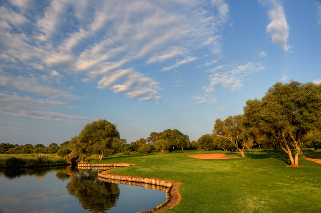 Lake on fairway with bunker and trees around at Son Antem - East Course