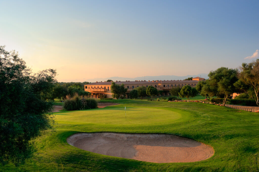 Bunker by hole with building in background at Son Antem - East Course