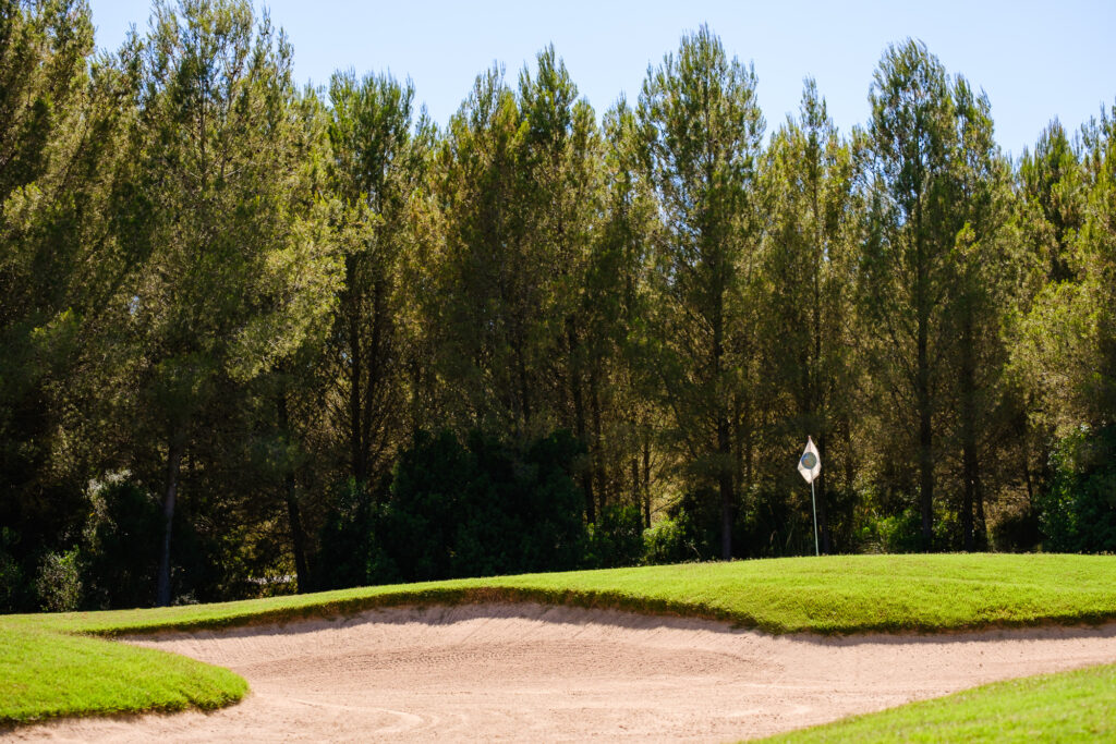 Bunker by hole with trees in background at Son Quint Golf Course