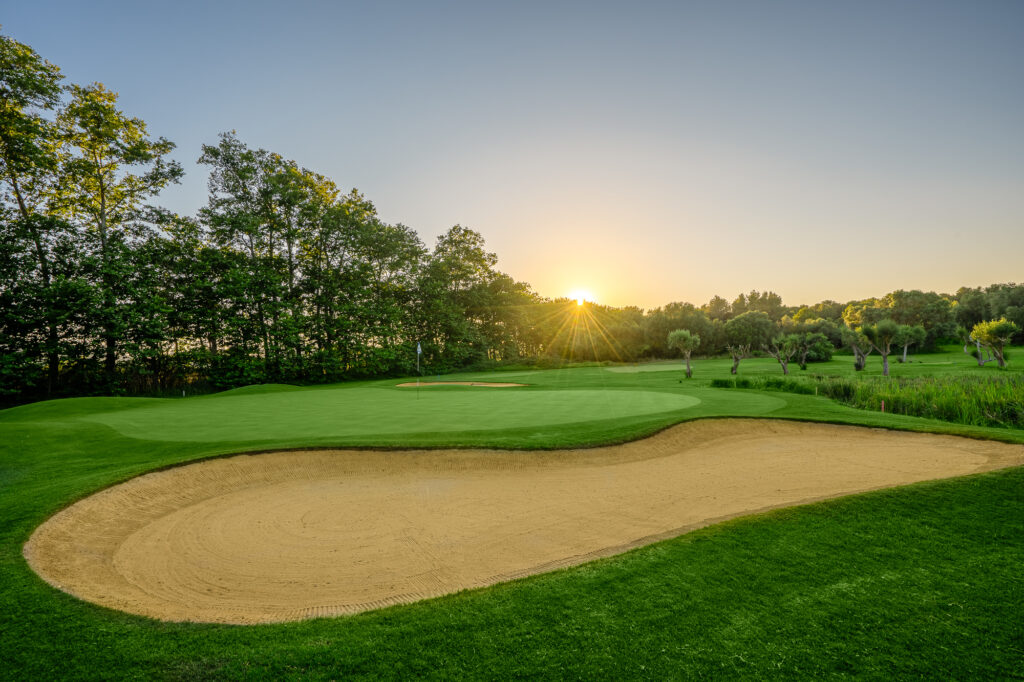 Hole with bunker and trees around with sunset at Son Servera Golf Course