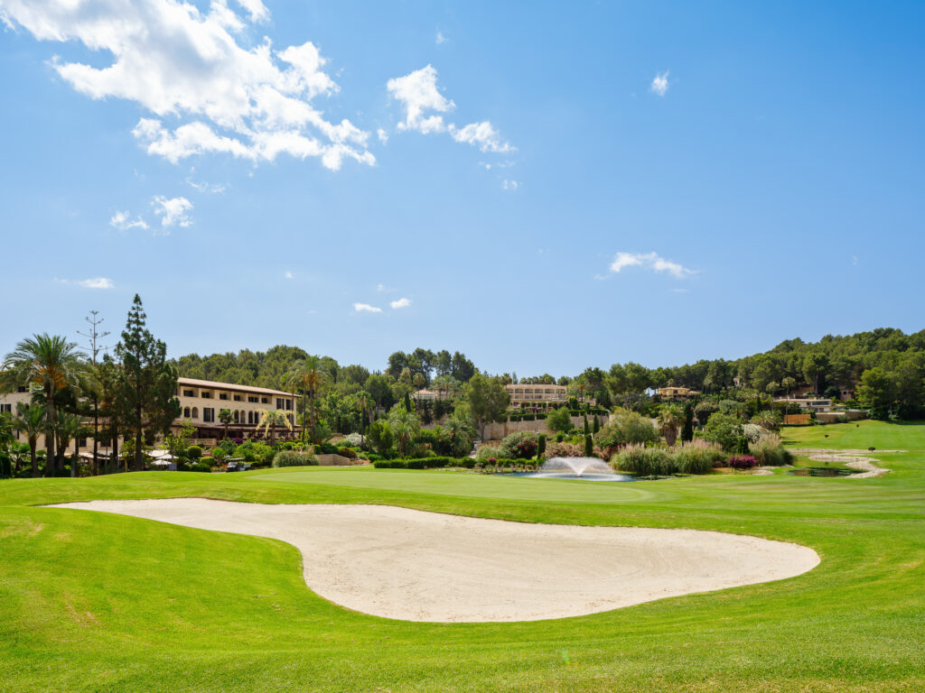 Bunker on fairway with trees and fountain in background at Son Vida Golf Course