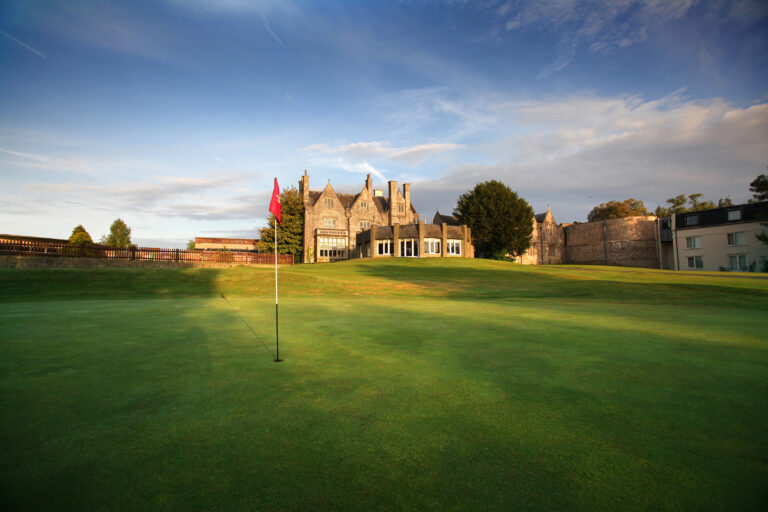 Hole with red flag at St Pierre - Mathern Course with building in background