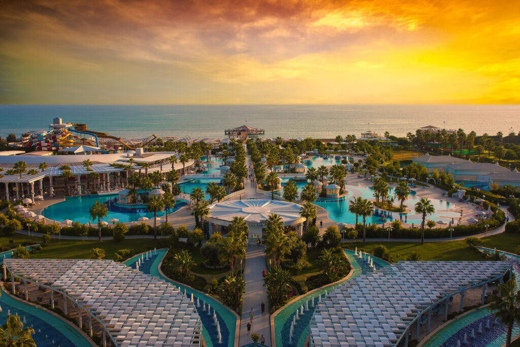 Outdoor pools at Sueno Hotels Deluxe Belek at sunset