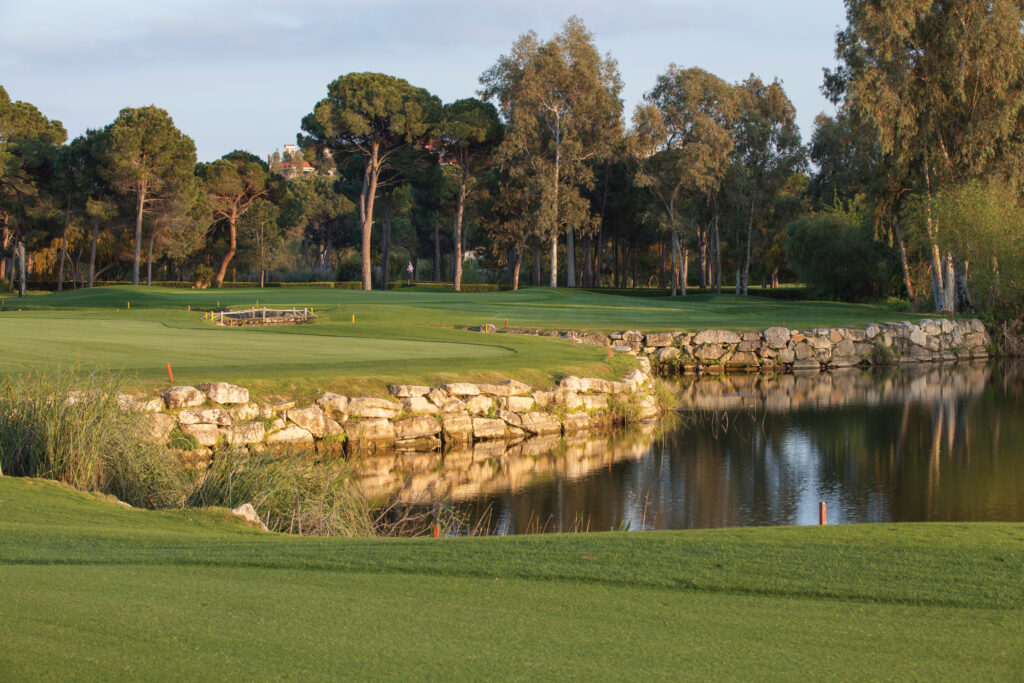 Fairway with trees around and a lake at PGA Sultan Golf Course