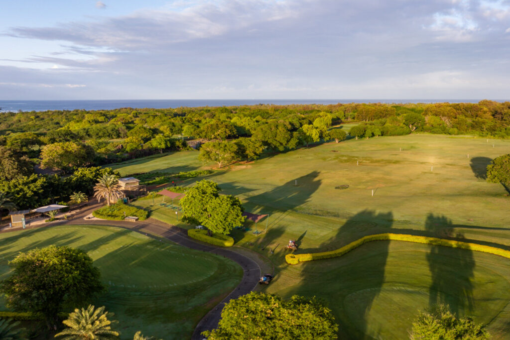 Aerial view of the driving range at Tamarina Golf Club with trees around