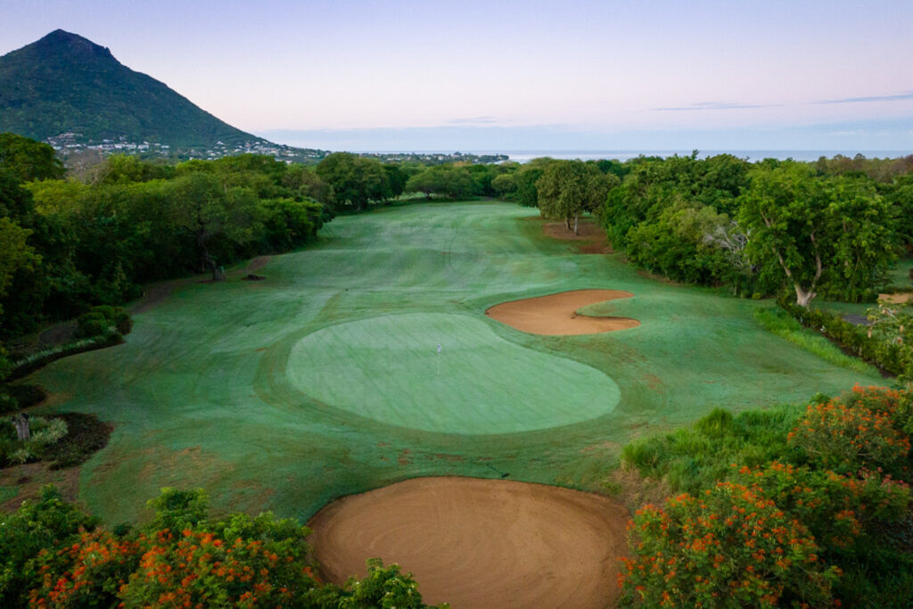 Hole with bunkers at Tamarina Golf Club with trees around