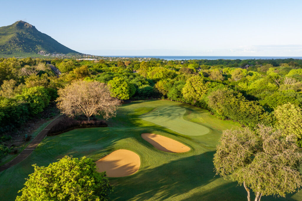 Hole with bunkers at Tamarina Golf Club with trees around