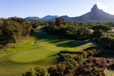 Hole with trees around at Tamarina Golf Club with mountain in distance