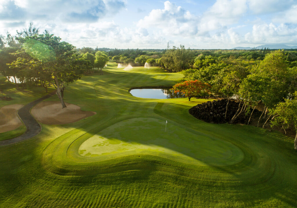 Hole with white flag at The Legend Golf Course with trees around