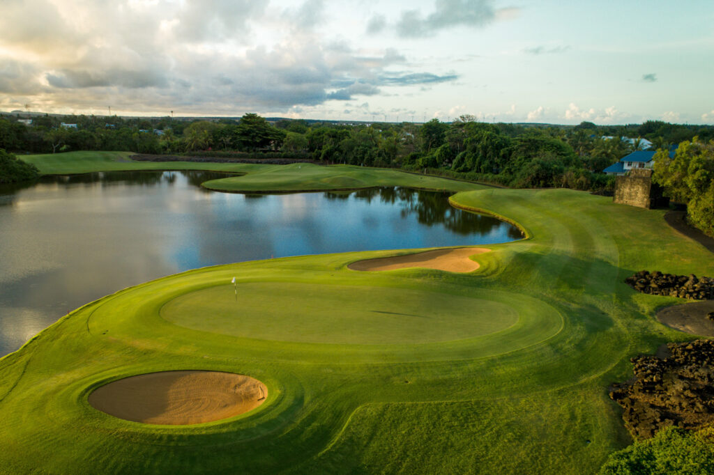 Hole with white flag and bunkers at The Links Golf Course with lake next to it