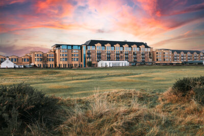 Exterior of the Old Course Hotel, Golf Resort & Spa with a pink sky