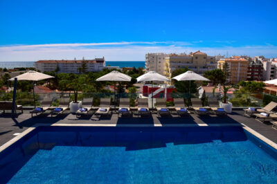 Outdoor pool with sun loungers at The Prime Energize Monte Gordo