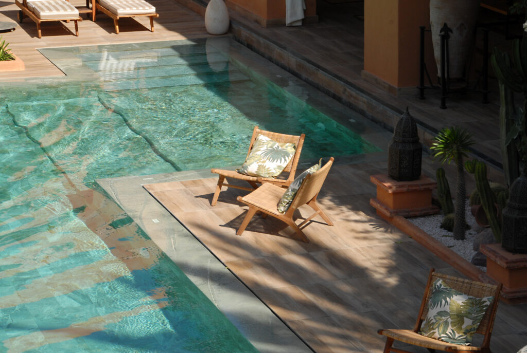 Outdoor pool with relaxing chairs at Tikida Golf Palace