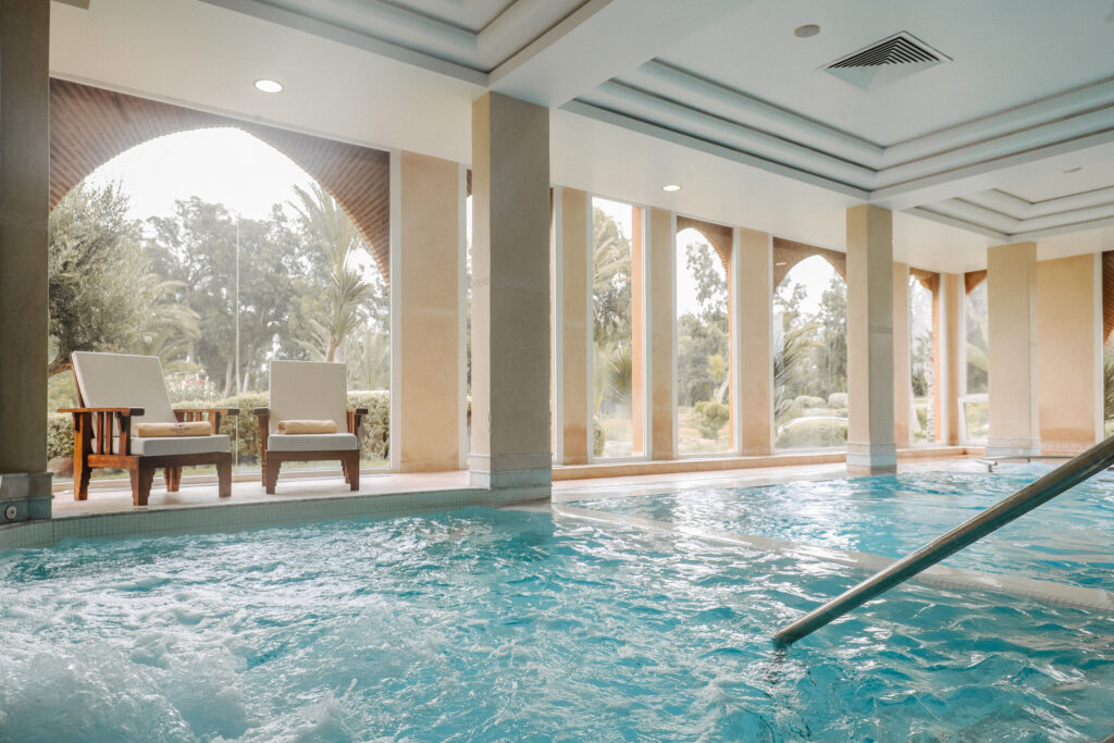 Indoor pool at Tikida Golf Palace with relaxing chairs