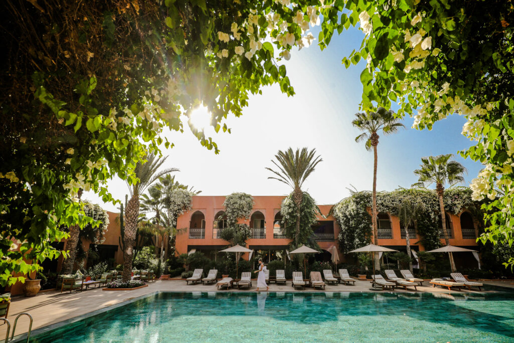 View of the exterior of Tikida Golf Palace with outdoor pool through the trees