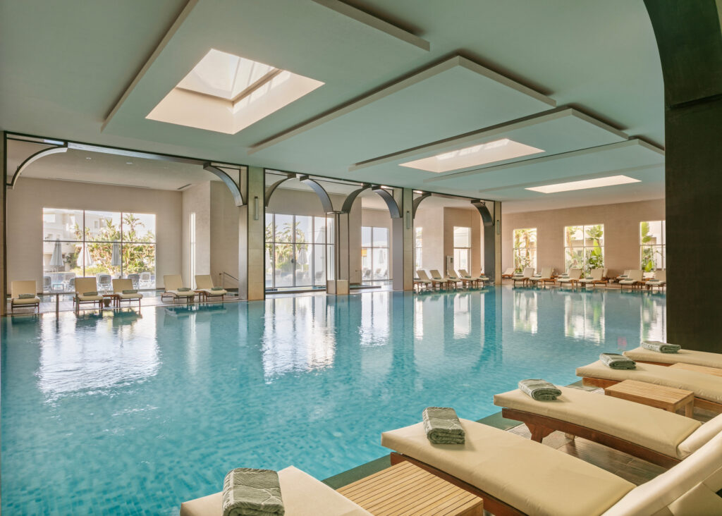 Indoor pool with loungers at Titanic Deluxe Golf Belek Hotel