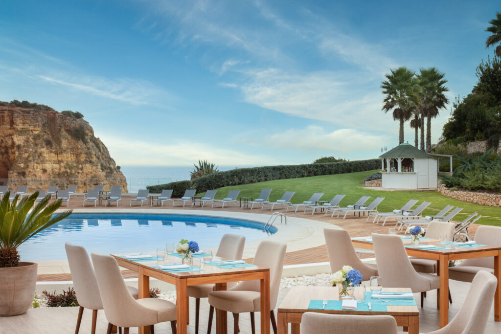 Outdoor pool with chairs and tables at Tivoli Carvoeiro