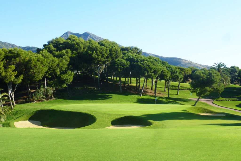 A hole with bunkers and trees around at Torrequebrada Golf Course