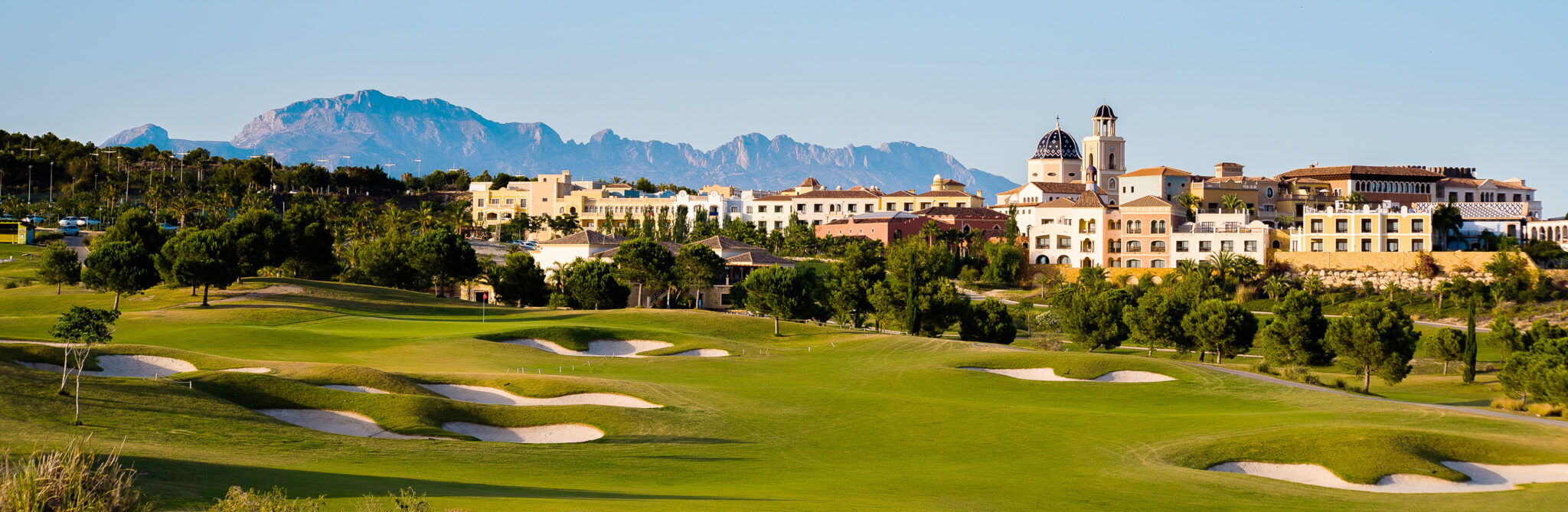 Bunkers on fairway with buildings in background at Villaitana - Poniente Course