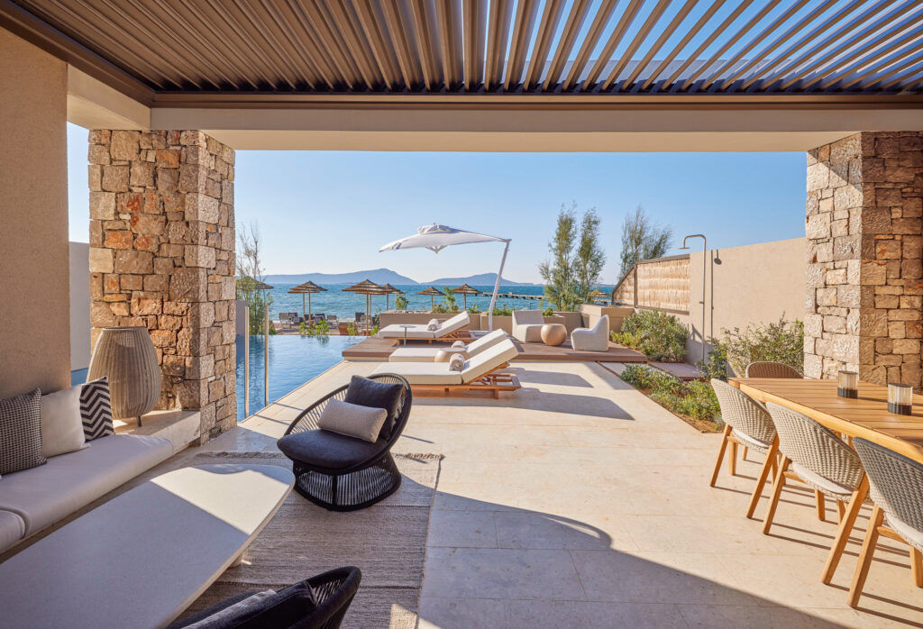 Outdoor seating with sun loungers by pool at W Costa Navarino