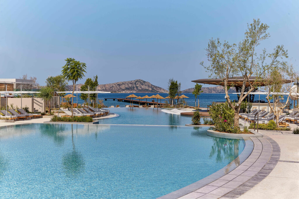 Outdoor pool at W Costa Navarino with loungers around and ocean view