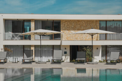 Exterior of West Cliffs Ocean Golf Resort with sun loungers and umbrellas