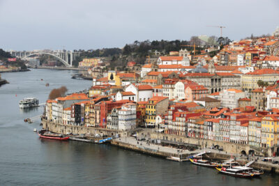 a picture of Porto city in Portugal with the river running on one side
