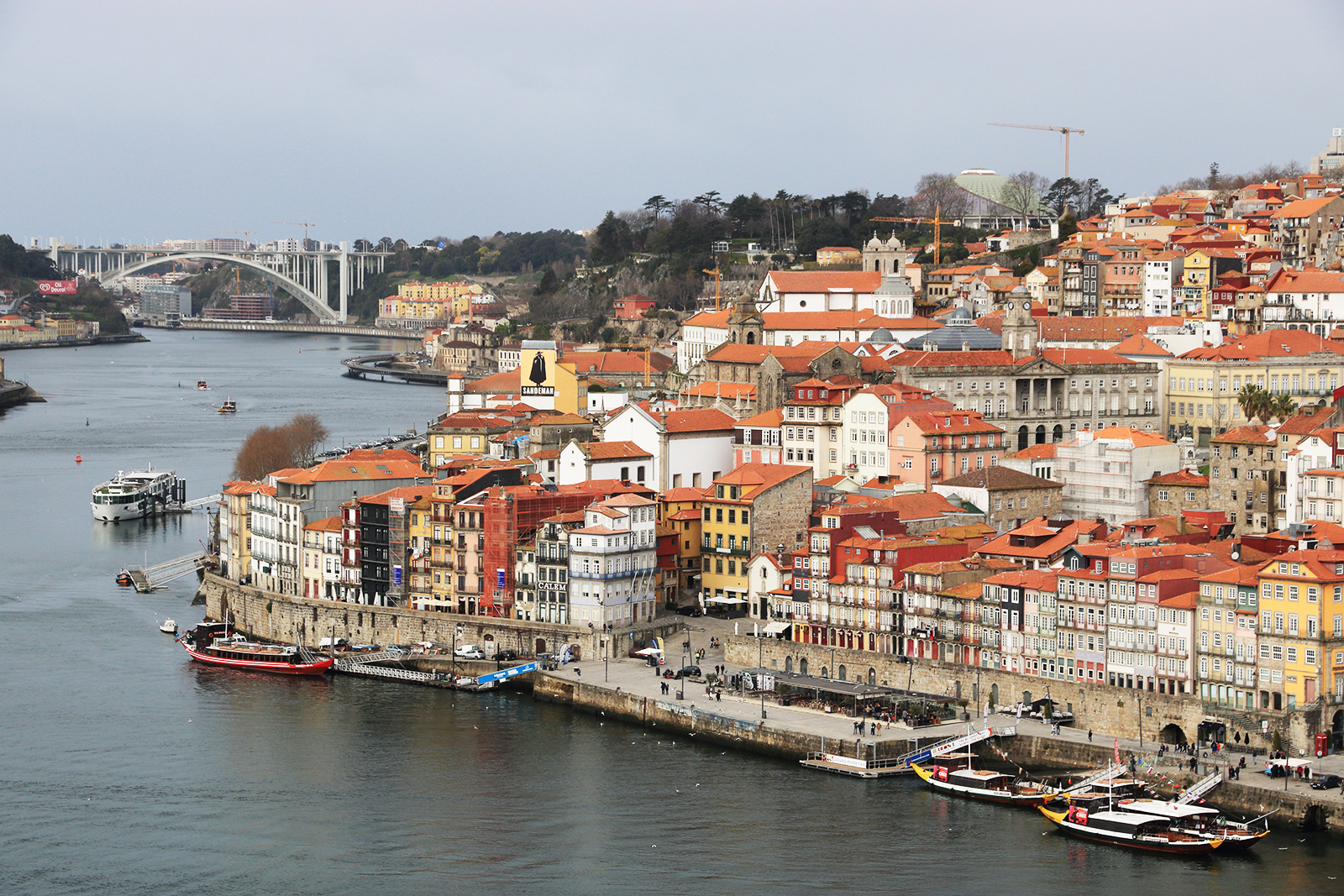 a picture of Porto city in Portugal with the river running on one side