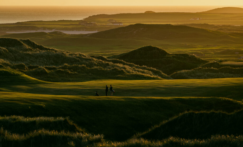 People on fairway at Carne Golf Links at sunset