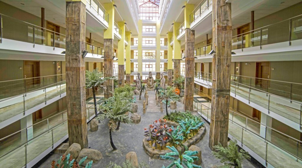 Indoor garden and statues in lobby at Holiday Polynesia Hotel