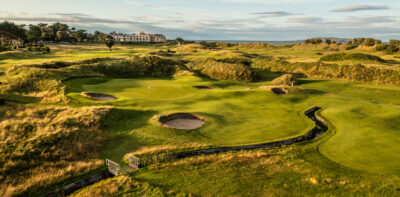 Hole with bunkers and a water hazard at Jameson Golf Links with mounds around and building in distance