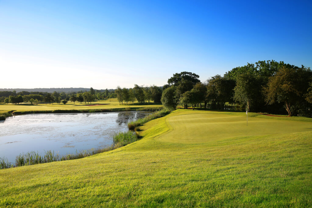 Lake on fairway with trees around at Belton Woods - Lakes Course with a hole with a white flag