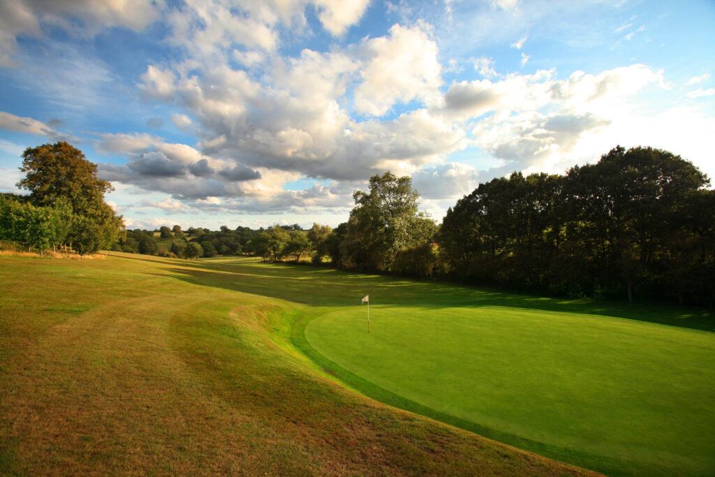 Hole with white flag at Breadsall Priory - Priory Course with trees around