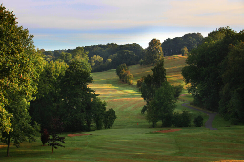 Fairway with trees around at Breadsall Priory - Moorland Course with hole in distance with red flag