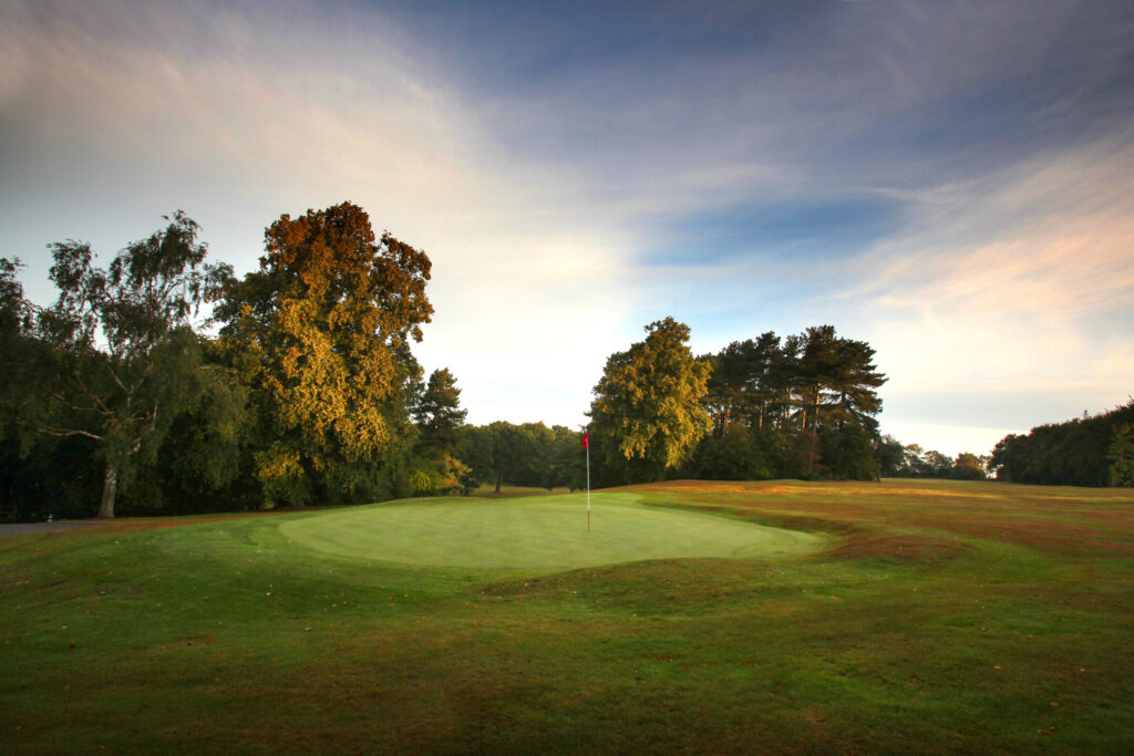 Hole with red flag and trees around at Breadsall Priory - Moorland Course