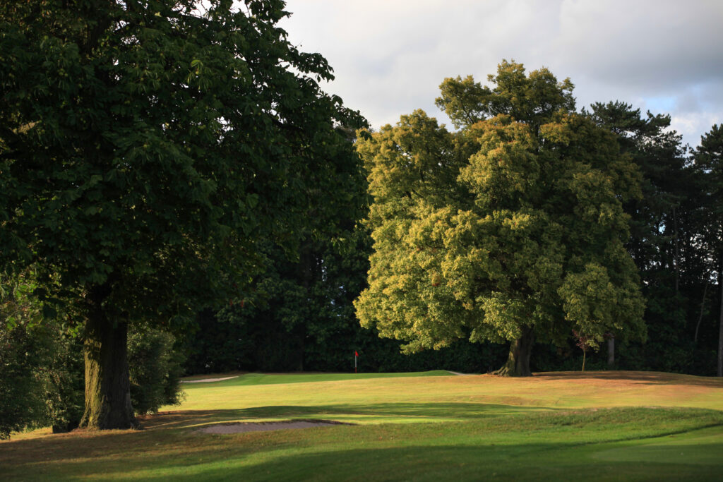 Fairway with trees around at Breadsall Priory - Priory Course with hole with red flag in distance