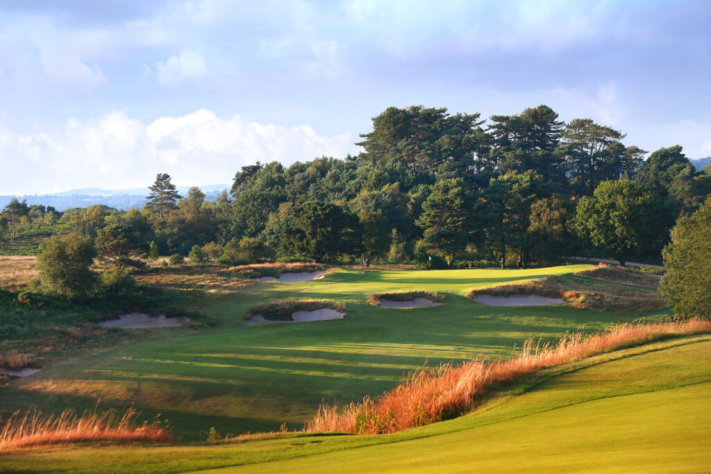 Fairway leading to hole with bunkers with trees in background at Broadstone Golf Club