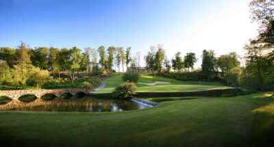 Lake on fairway at Druids Glen Golf Course with trees around