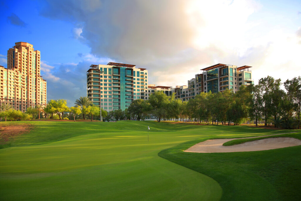 Hole with bunkers at Emirates Golf Club - The Faldo with buildings in distance