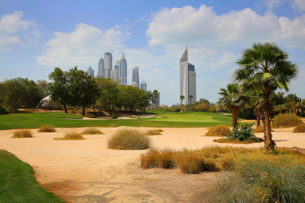 Bunkers on fairway at Emirates Golf Club - The Faldo with trees around and buildings in distance