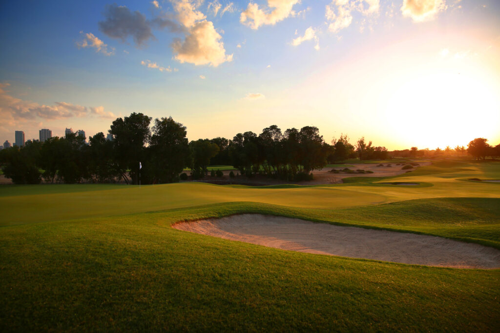 Hole with bunker at Emirates Golf Club - The Faldo with trees in background at sunset