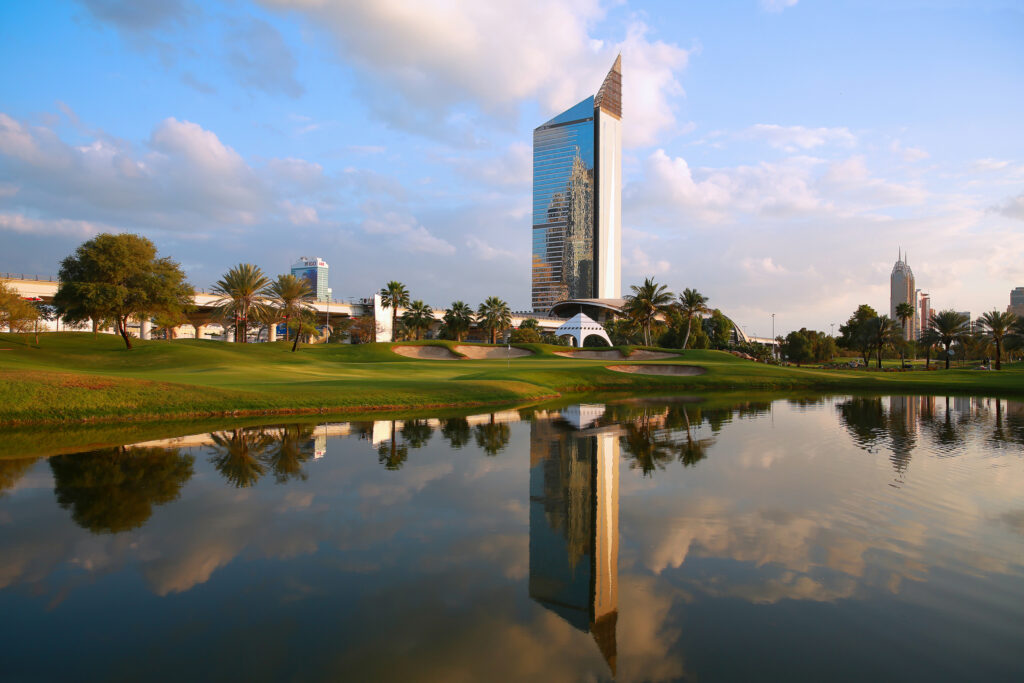 Bunkers on fairway at Emirates Golf Club - The Faldo with lake next to it and buildings in background