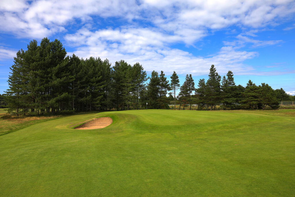 Hole with bunker and trees in background at Formby Golf Club