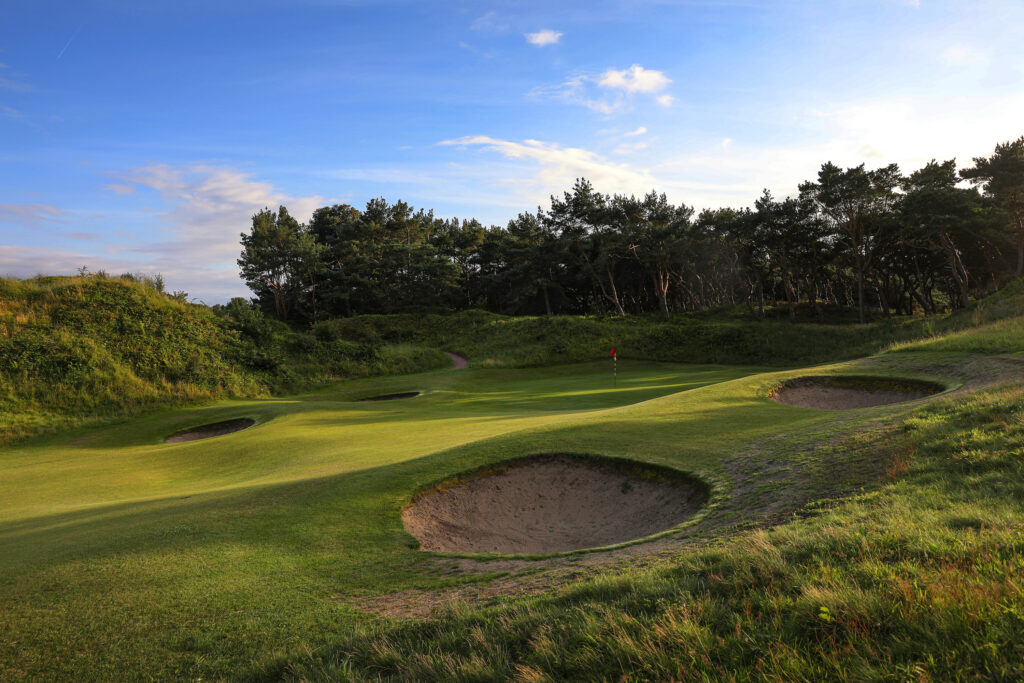 Hole with red flag and bunkers around at Formby Ladies Golf Club