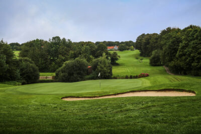 Hole with bunker at Golf Saint Omer with trees around