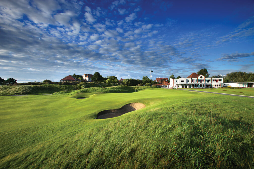 Hole with bunkers at Hillside Golf Club with buildings in background