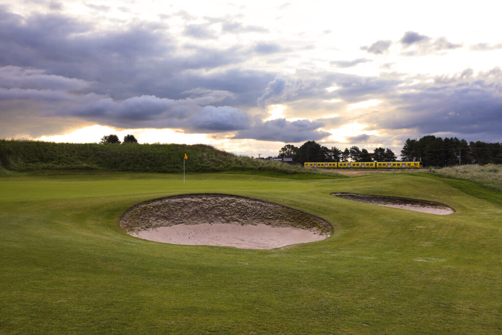 Hole with bunkers at Hillside Golf Club with train in background