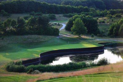 Aerial view of hole with lake and trees around at The London Golf Club