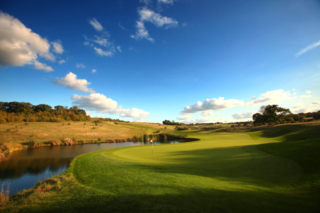 Hole with white flag with a lake at The London Golf Club